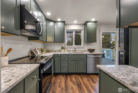 a kitchen with stainless steel appliances granite countertop sink stove top oven and cabinets