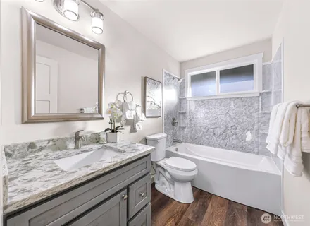 a bathroom with a granite countertop toilet a sink and bathtub