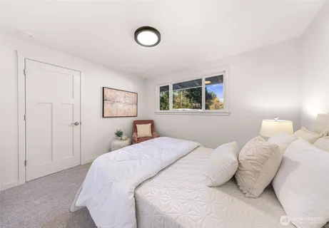 a bedroom with a bed and a painting on the wall