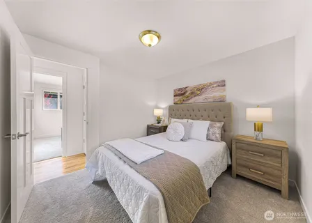 a bedroom with a bed and a lamp on a dresser