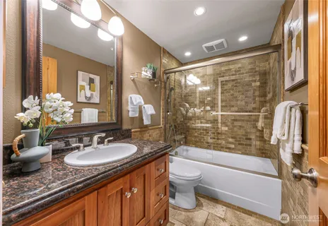 a bathroom with a granite countertop sink toilet and shower