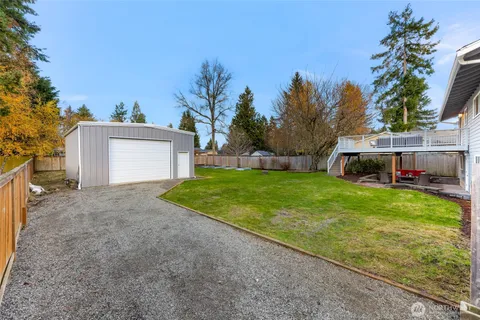 a view of a house with backyard and trees
