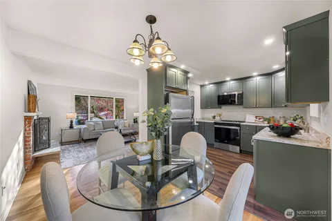a living room with fireplace furniture and a view of kitchen