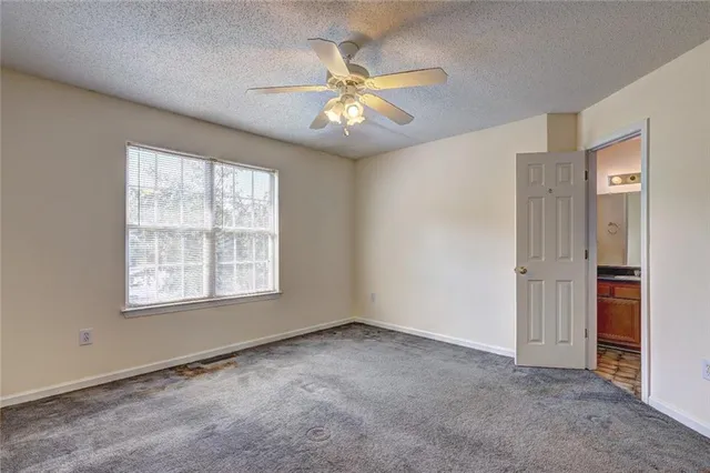an empty room with fan and windows
