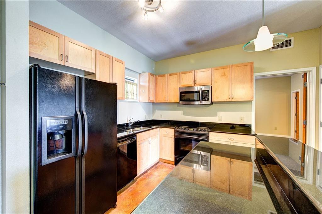 711 West 26th Street, Unit 506 Austin, TX 78705 - Photo 4 of 16 a kitchen with stainless steel appliances granite countertop a refrigerator a stove and a sink with granite countertops