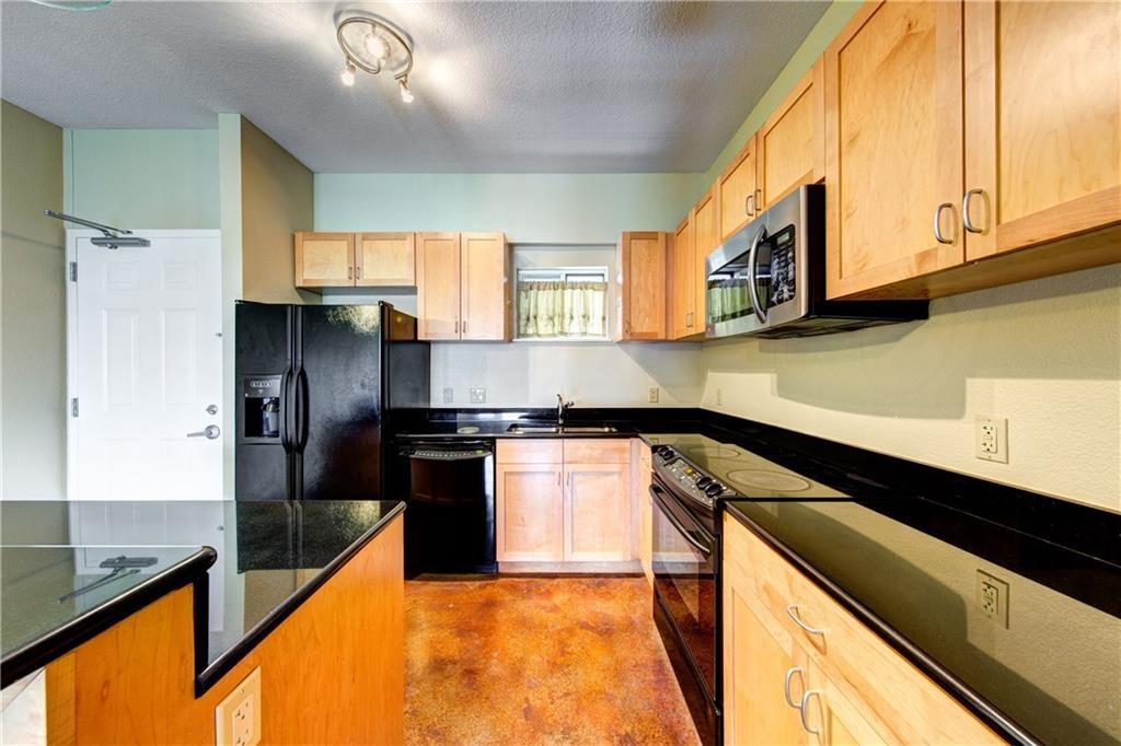 711 West 26th Street, Unit 506 Austin, TX 78705 - Photo 5 of 16 a kitchen with stainless steel appliances granite countertop a stove a sink and a microwave
