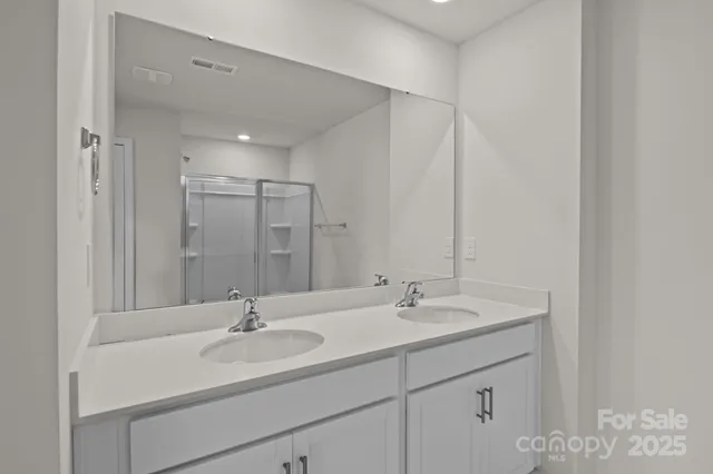 a bathroom with double vanity sink and a mirror