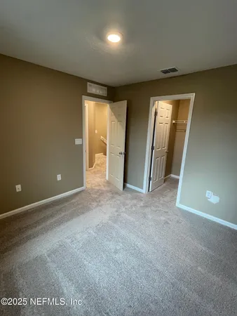 an empty room with closet and wooden door
