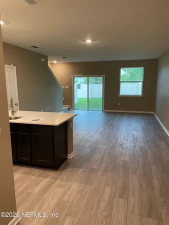 a view of a room with a ceiling fan and window