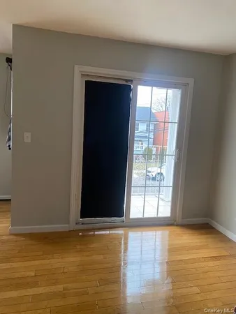 a view of a livingroom with wooden floor and a window