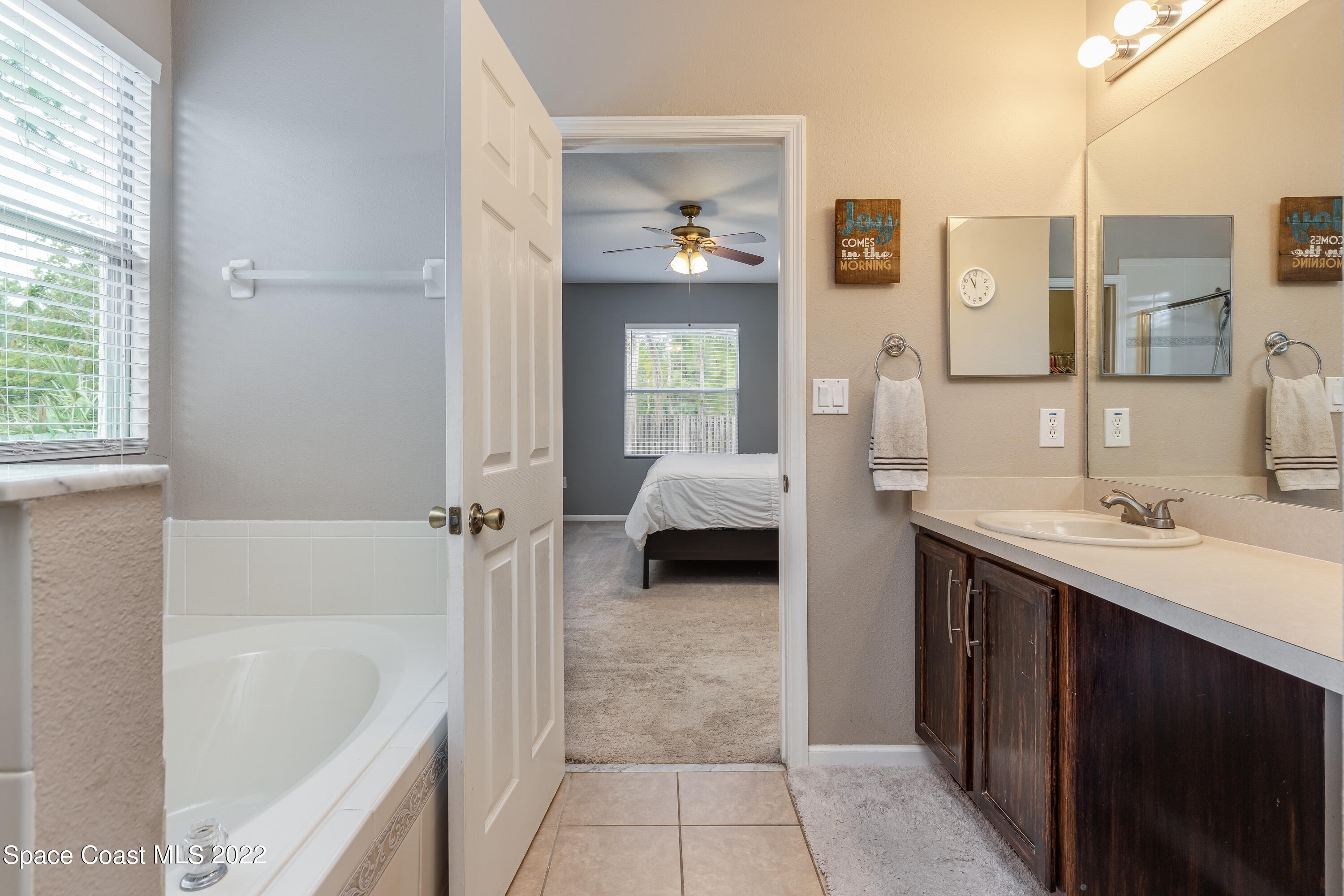 1114 Sexton Road Southwest Palm Bay, FL 32908 - Photo 14 of 19 a en suite spacious bathroom with a double vanity sink a mirror and a bathtub