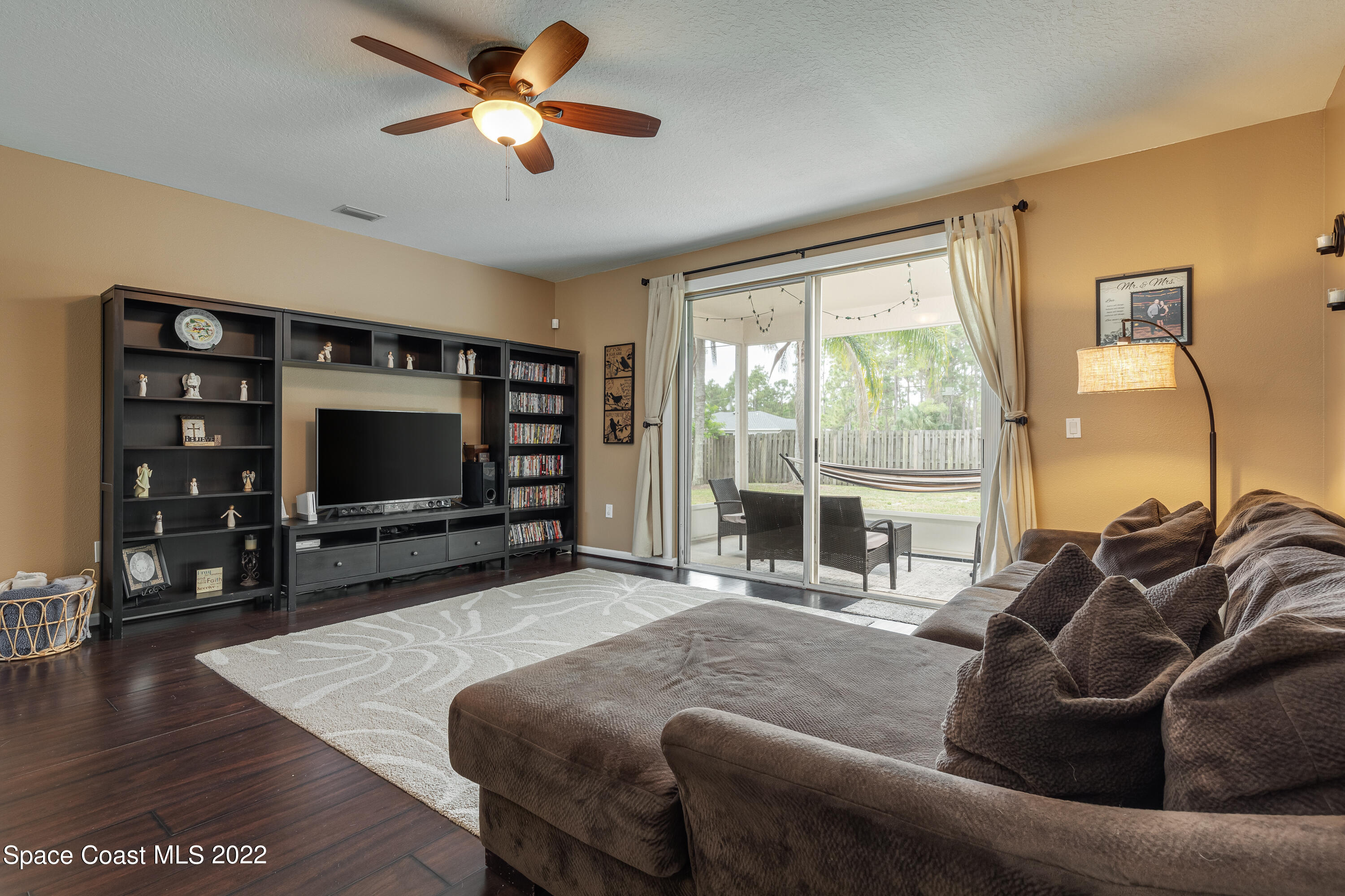 1114 Sexton Road Southwest Palm Bay, FL 32908 - Photo 9 of 19 a living room with furniture a flat screen tv and a large window