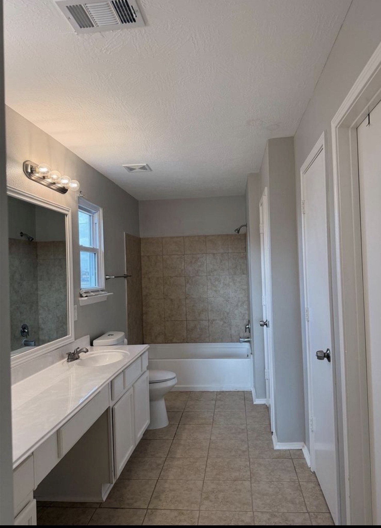 4707 East Parma Drive Rosenberg, TX 77471 - Photo 18 of 22 a bathroom with a double vanity sink a toilet and mirror