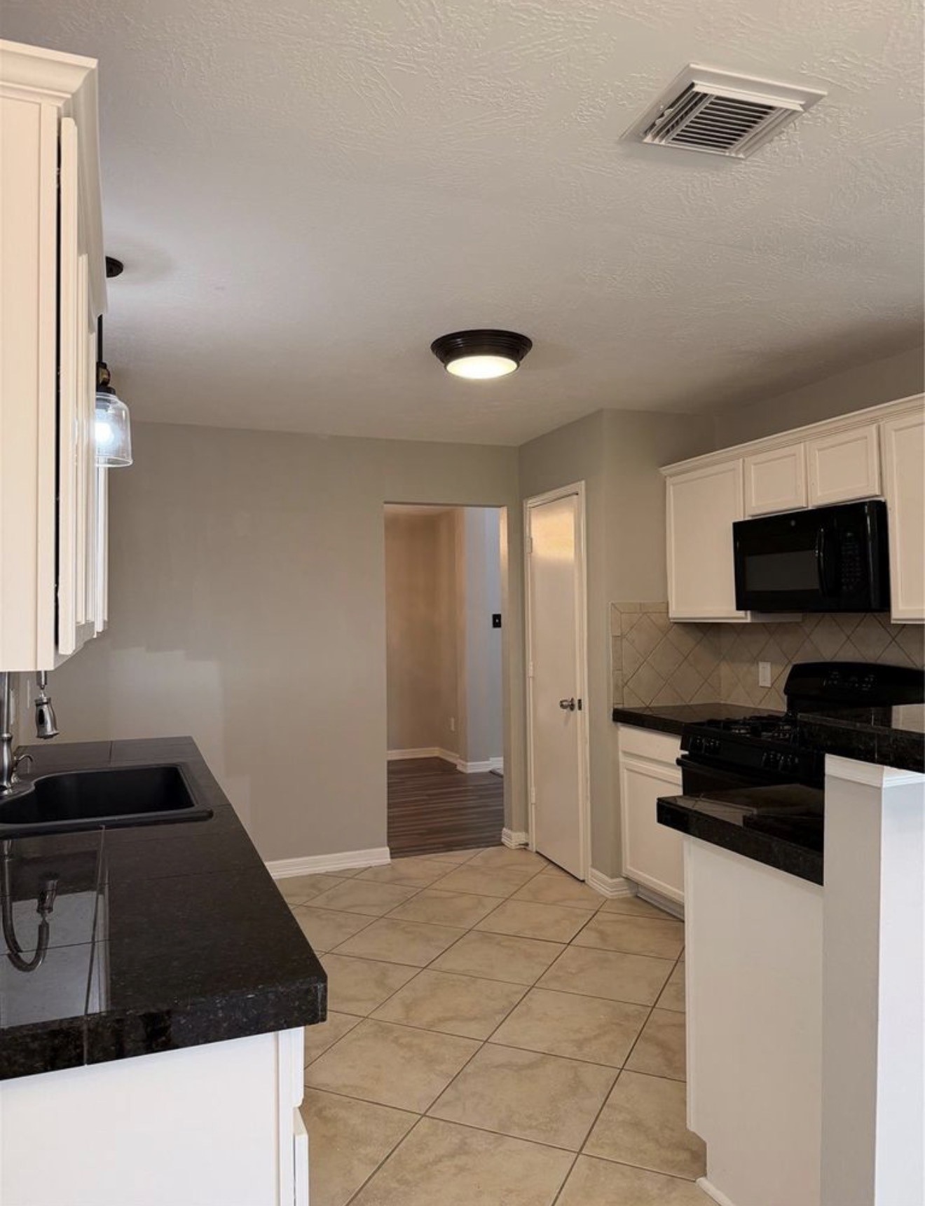 4707 East Parma Drive Rosenberg, TX 77471 - Photo 6 of 22 a kitchen that has a sink and a stove in it