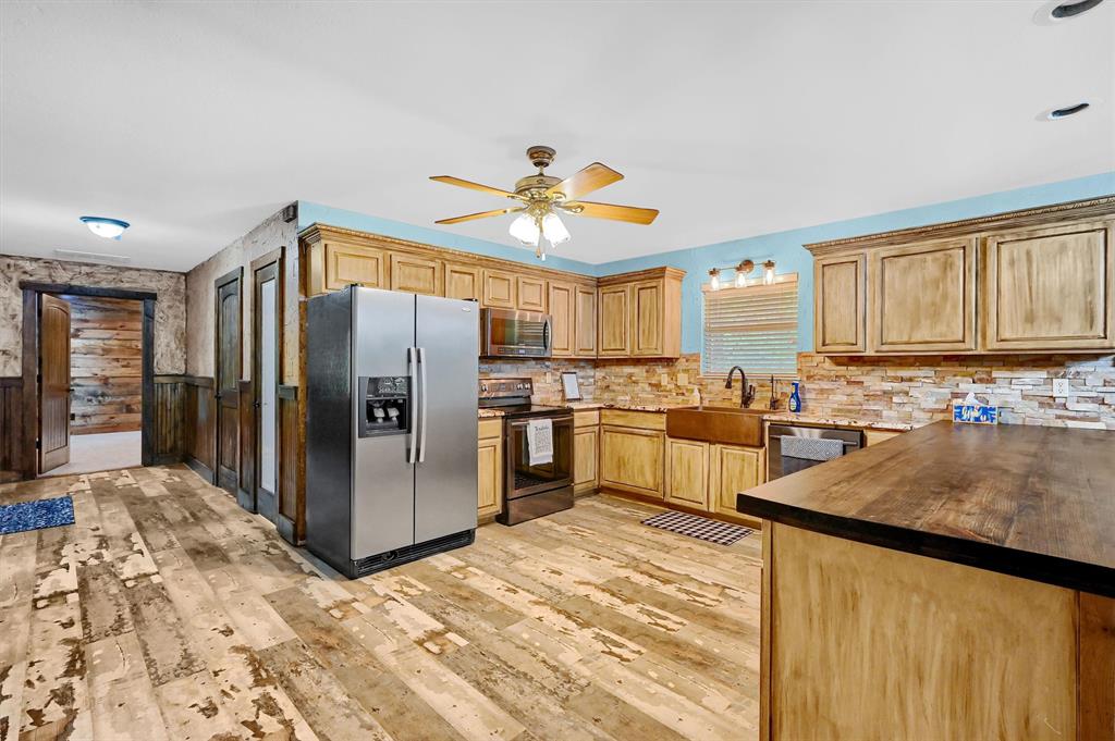 2003 Flowing Wells Road Pottsboro, TX 75076 - Photo 12 of 39 Kitchen with tasteful backsplash, ceiling fan, light hardwood / wood-style floors, appliances with stainless steel finishes, and sink