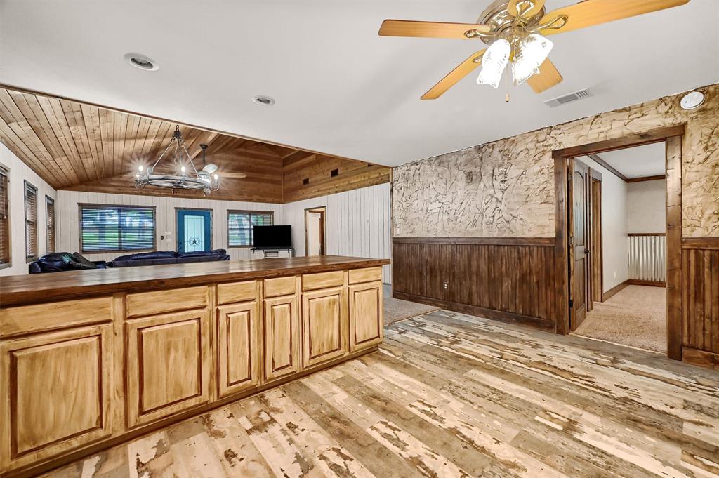 2003 Flowing Wells Road Pottsboro, TX 75076 - Photo 15 of 39 Kitchen with wooden walls, light colored carpet, lofted ceiling, wooden ceiling, and ceiling fan