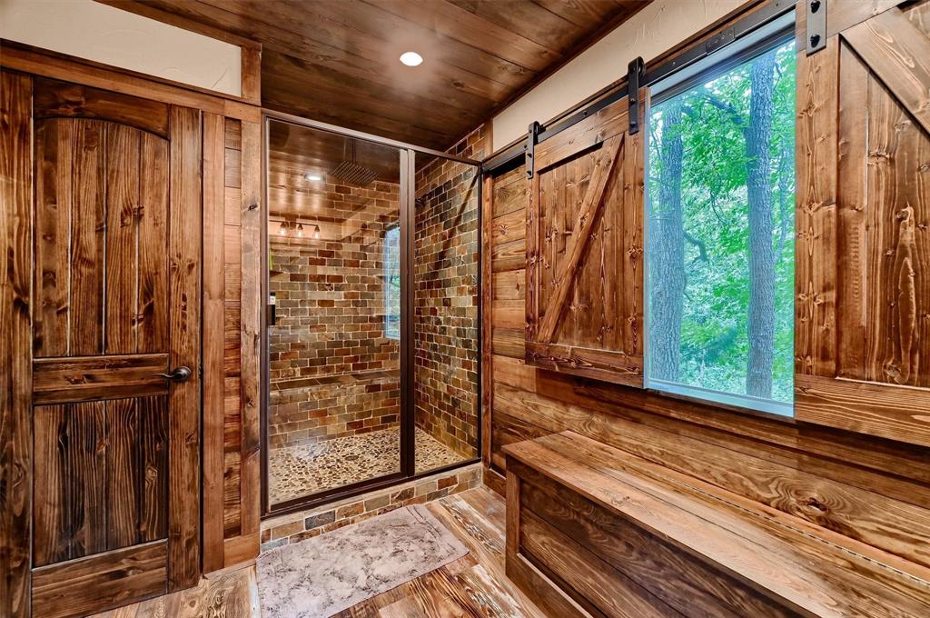 2003 Flowing Wells Road Pottsboro, TX 75076 - Photo 25 of 39 Bathroom featuring wooden walls, hardwood / wood-style flooring, a shower with door, and wood ceiling