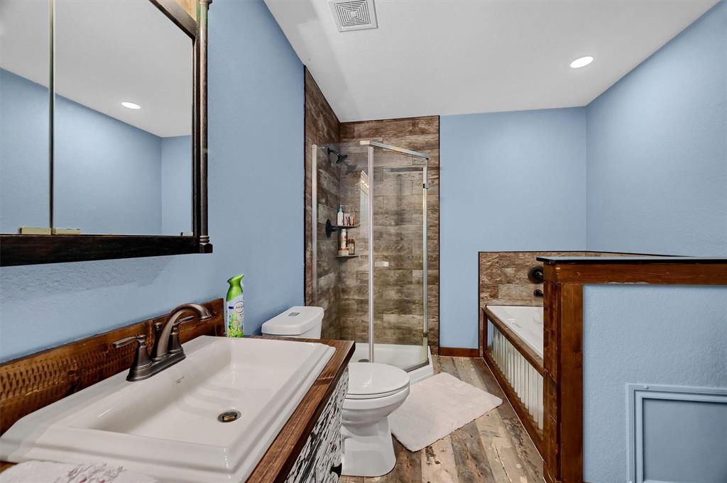 2003 Flowing Wells Road Pottsboro, TX 75076 - Photo 29 of 39 Full bathroom featuring hardwood / wood-style floors, vanity, plus walk in shower, and toilet