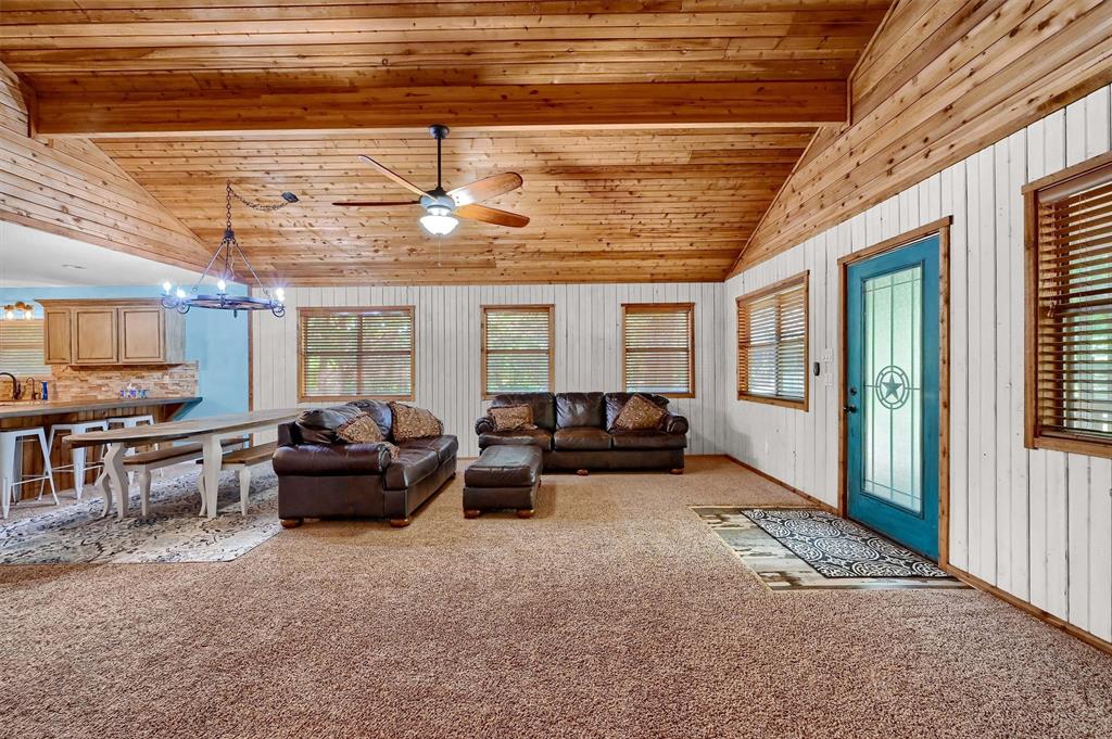 2003 Flowing Wells Road Pottsboro, TX 75076 - Photo 8 of 39 Living room with beamed ceiling, light colored carpet, ceiling fan with notable chandelier, high vaulted ceiling, and wooden ceiling