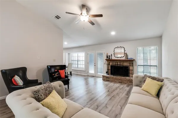 a living room with furniture a fireplace and a chandelier