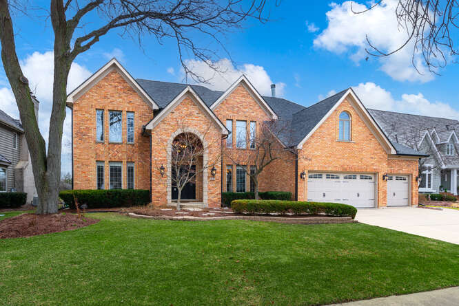 a front view of a house with a yard and garage