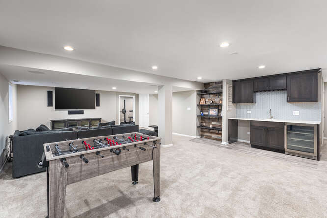 1530 White Eagle Drive Naperville, IL 60564 - Photo 30 of 43 a room with furniture a flat screen tv and a kitchen view