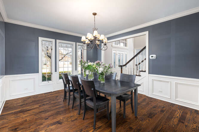 1530 White Eagle Drive Naperville, IL 60564 - Photo 4 of 43 a dining room with wooden floor a chandelier a wooden table and chairs