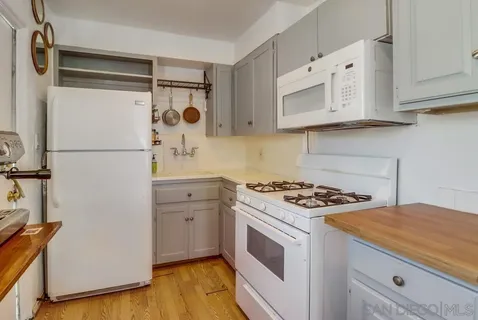 a kitchen with white cabinets and white appliances