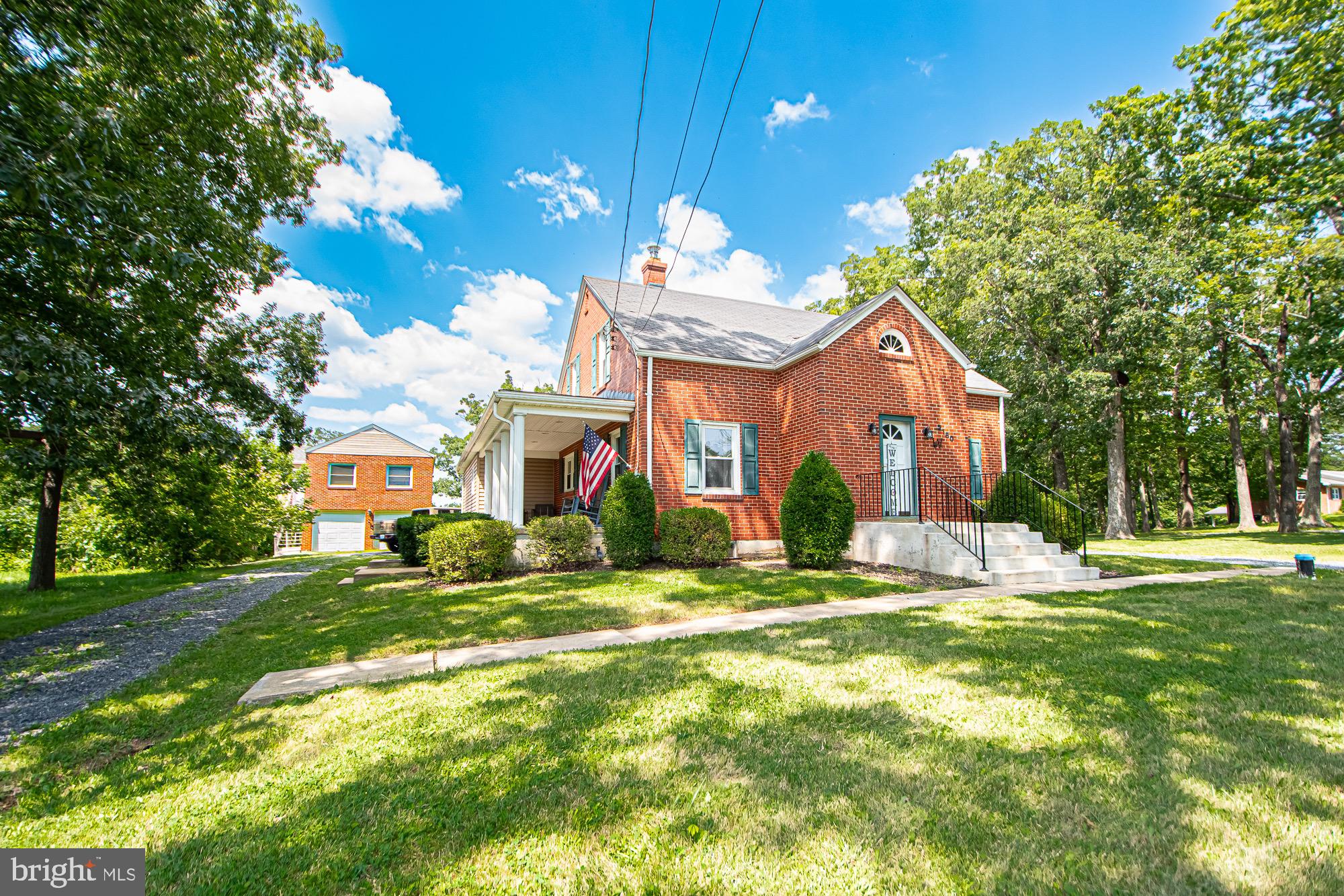 a view of a house with a big yard and large trees
