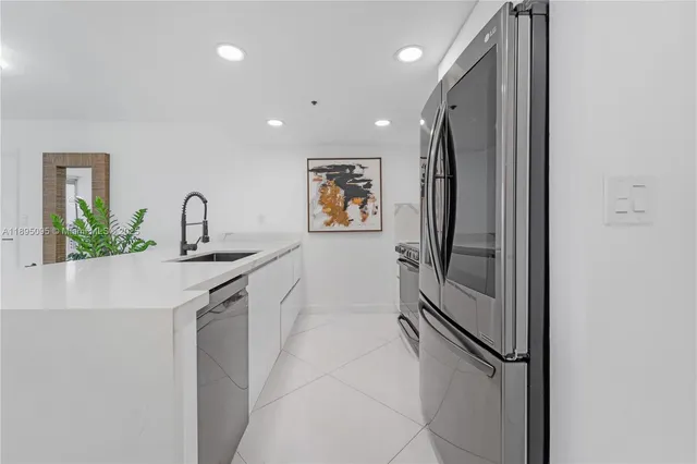a kitchen with stainless steel appliances granite countertop a refrigerator and a sink
