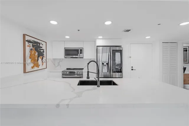 a view of kitchen with sink and refrigerator