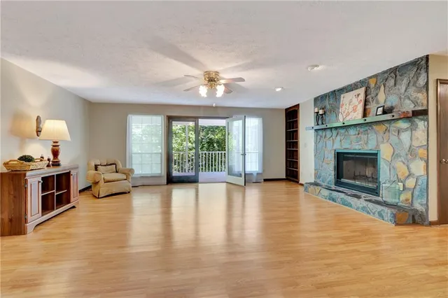 a view of an empty room with a fireplace and a window