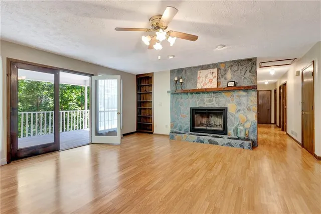 a view of an empty room with a fireplace and a window