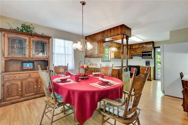 a dining room with furniture a chandelier and window