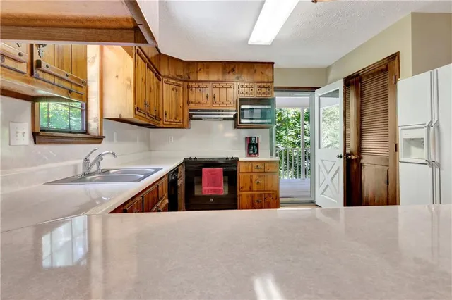 a kitchen with stainless steel appliances granite countertop a sink a stove and a refrigerator