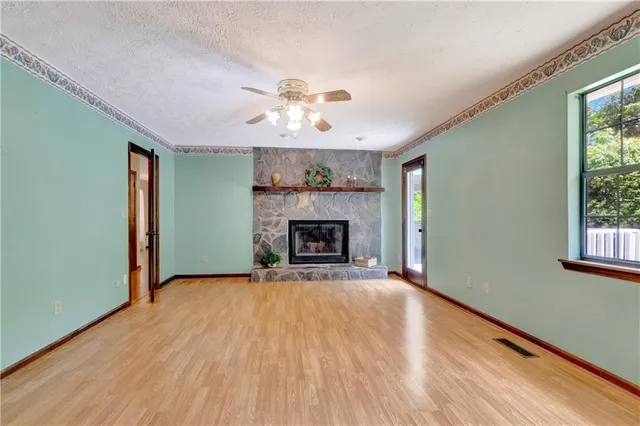 a view of an empty room with a window and fireplace