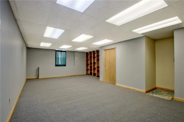 a view of an empty room with closet and a window