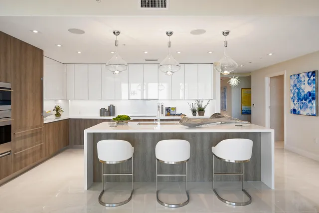a kitchen with stainless steel appliances granite countertop a table and chairs in it