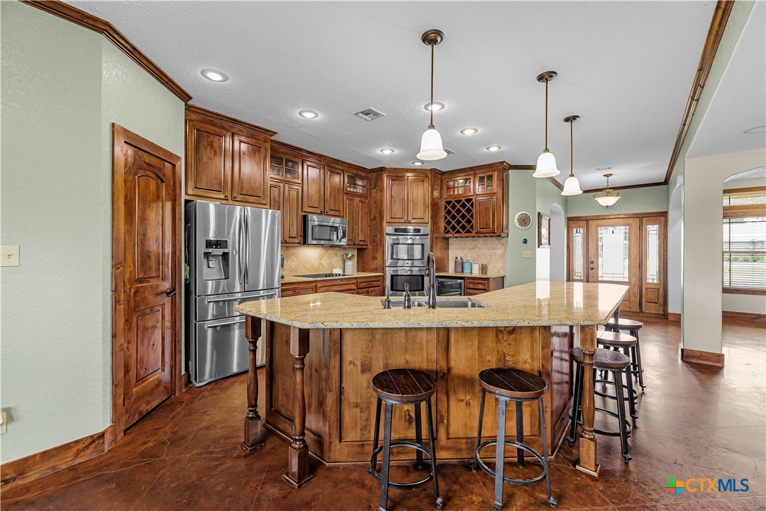 759 Richter Road Inez, TX 77968 - Photo 24 of 48 a kitchen with stainless steel appliances a dining table chairs refrigerator and cabinets