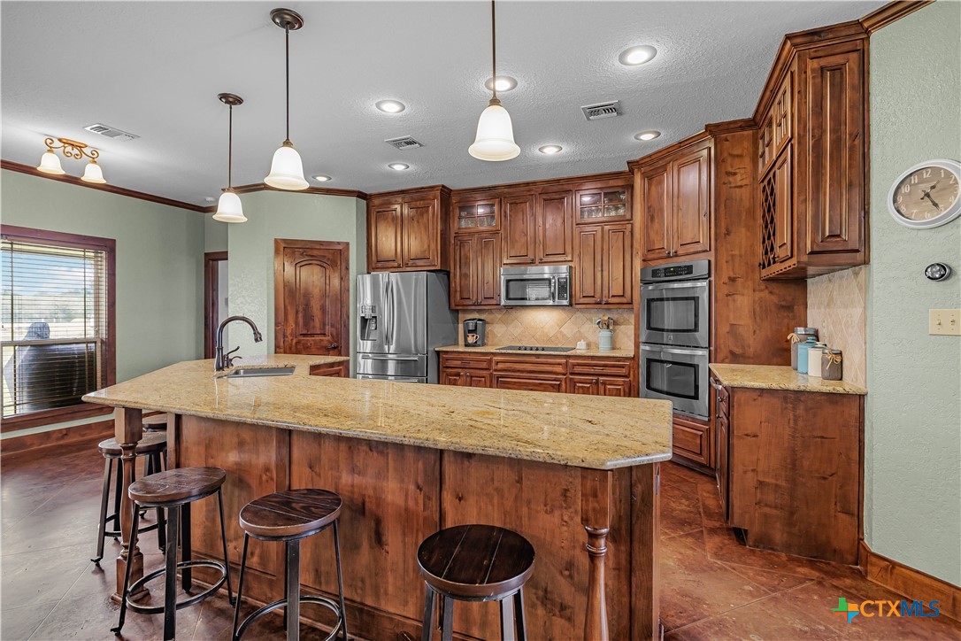 759 Richter Road Inez, TX 77968 - Photo 25 of 48 a kitchen with stainless steel appliances granite countertop a sink a stove a refrigerator and chairs