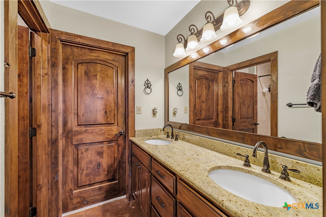759 Richter Road Inez, TX 77968 - Photo 27 of 48 a bathroom with a granite countertop sink a mirror a vanity and a shower