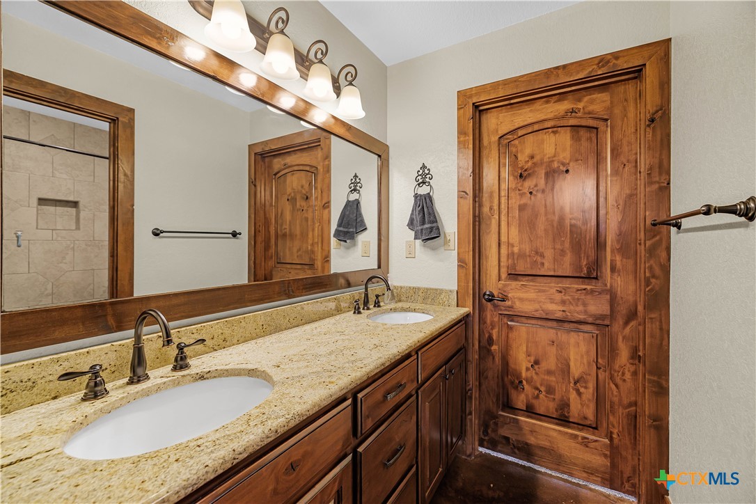 759 Richter Road Inez, TX 77968 - Photo 32 of 48 a bathroom with a granite countertop sink a mirror and a vanity