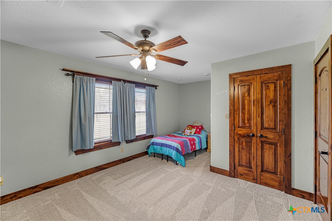 759 Richter Road Inez, TX 77968 - Photo 35 of 48 a bedroom with a bed and a chandelier