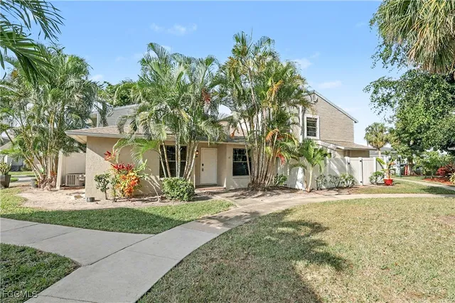 a front view of a house with a yard and potted plants