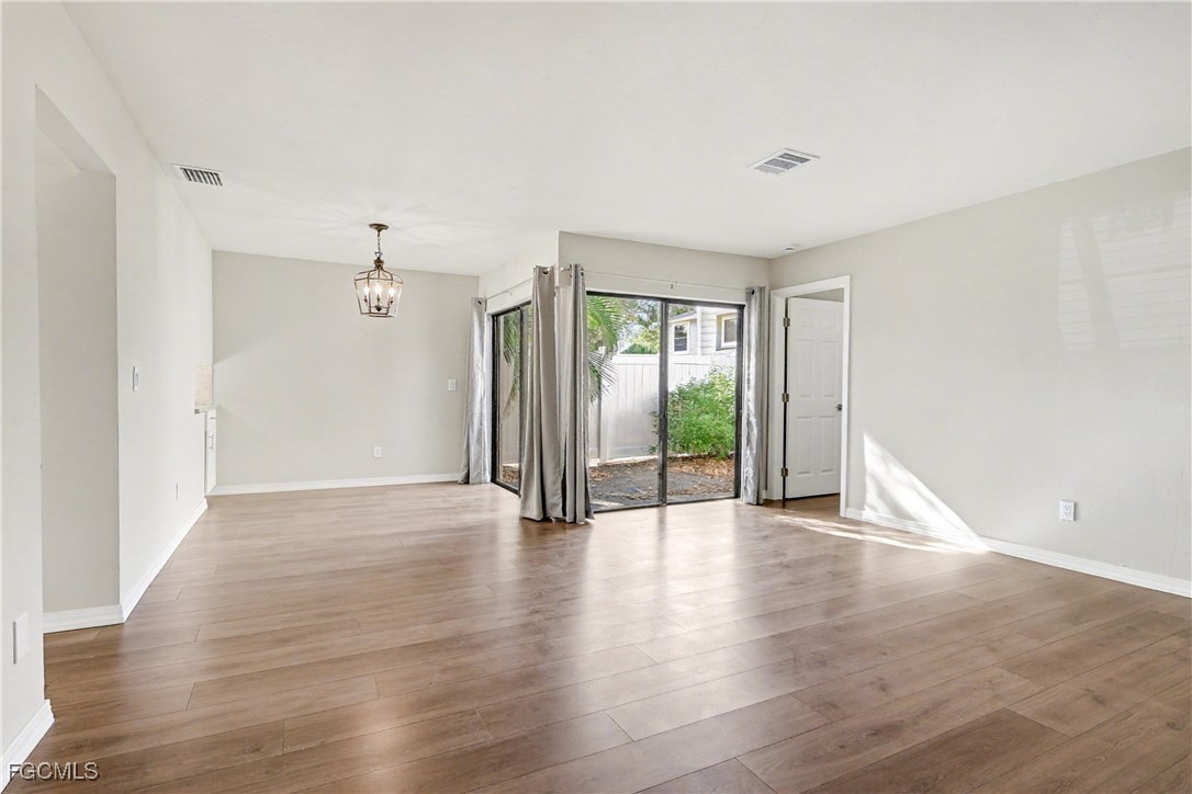 1416 Southwest 50th Street, Unit 63 Cape Coral, FL 33914 - Photo 12 of 23 a view of an empty room with wooden floor and a window