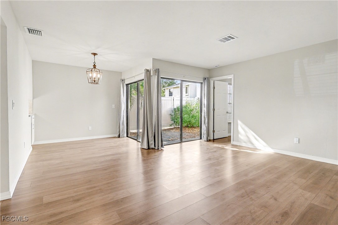 1416 Southwest 50th Street, Unit 63 Cape Coral, FL 33914 - Photo 13 of 23 a view of an empty room with wooden floor and a window