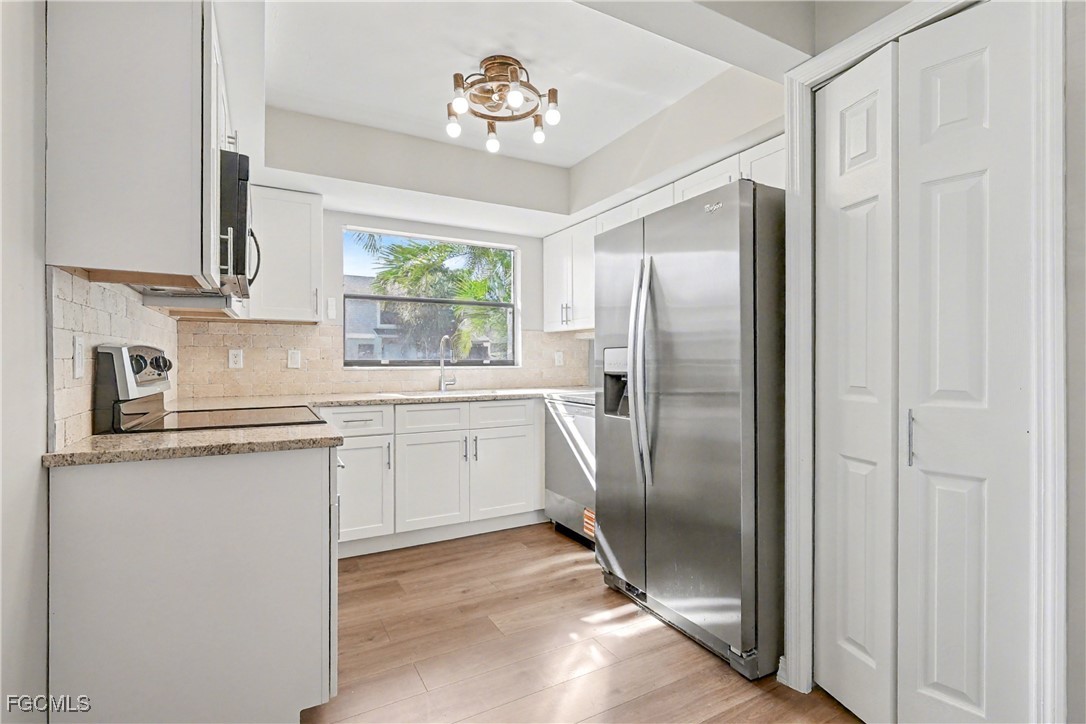 1416 Southwest 50th Street, Unit 63 Cape Coral, FL 33914 - Photo 16 of 23 a kitchen with stainless steel appliances a refrigerator sink and cabinets