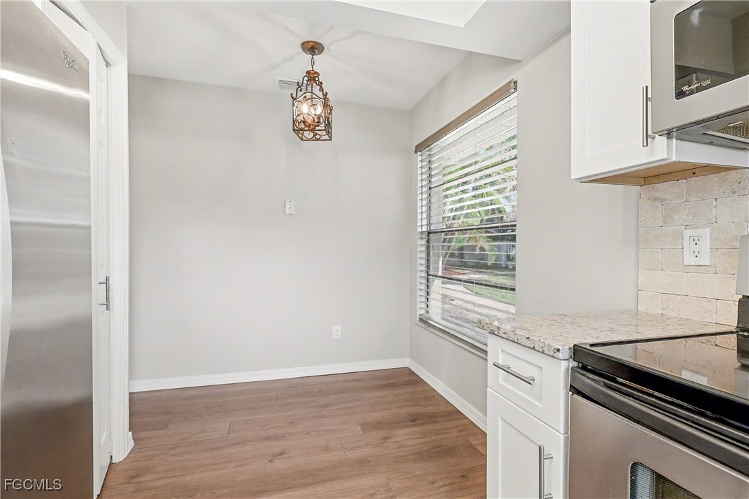1416 Southwest 50th Street, Unit 63 Cape Coral, FL 33914 - Photo 17 of 23 a kitchen with a wooden floor and a stove top oven