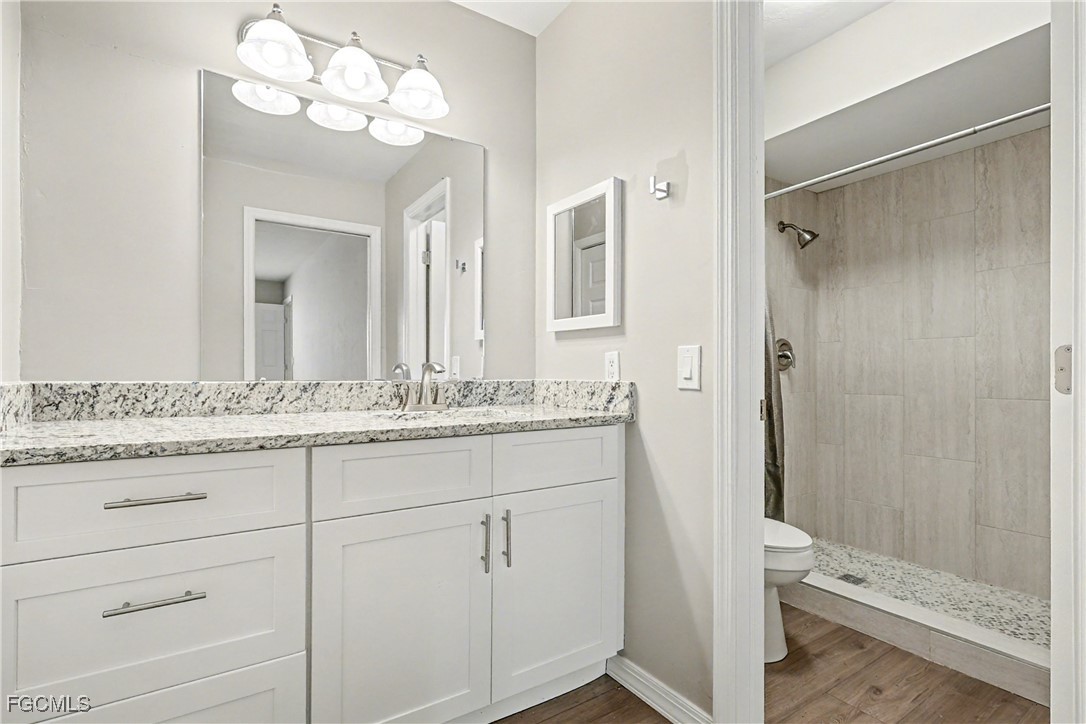 1416 Southwest 50th Street, Unit 63 Cape Coral, FL 33914 - Photo 19 of 23 a bathroom with a granite countertop sink mirror and a shower