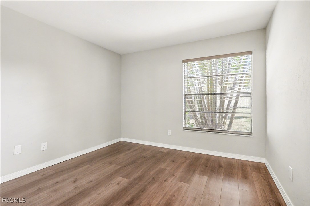 1416 Southwest 50th Street, Unit 63 Cape Coral, FL 33914 - Photo 20 of 23 an empty room with wooden floor and windows
